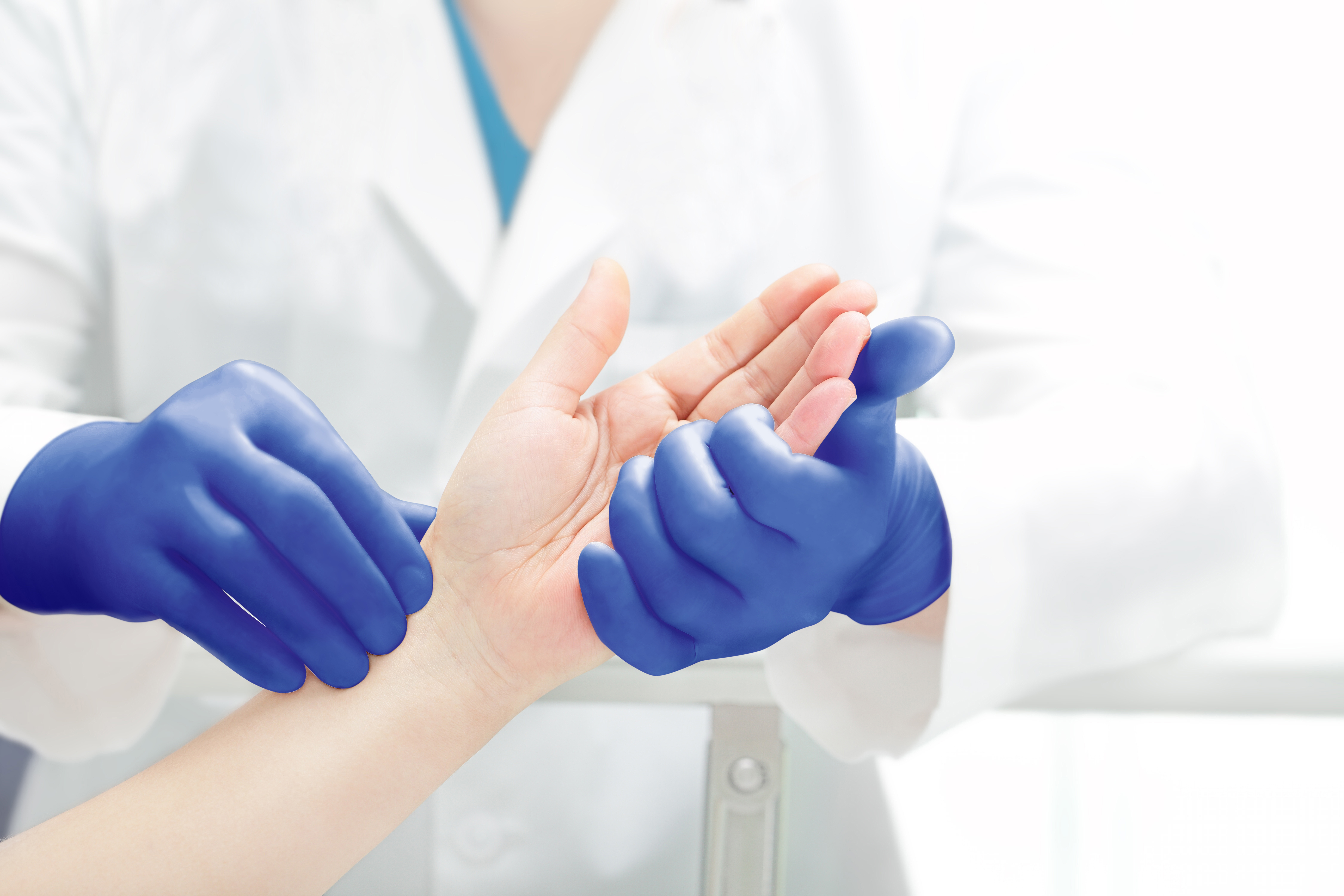 MICRO-TOUCH Blue Nitrile Primary Healthcare Application - Doctor Examining Hand (1).jpg